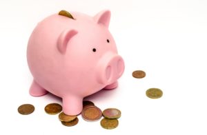 Financing modern vision correction coins around a pink piggy bank