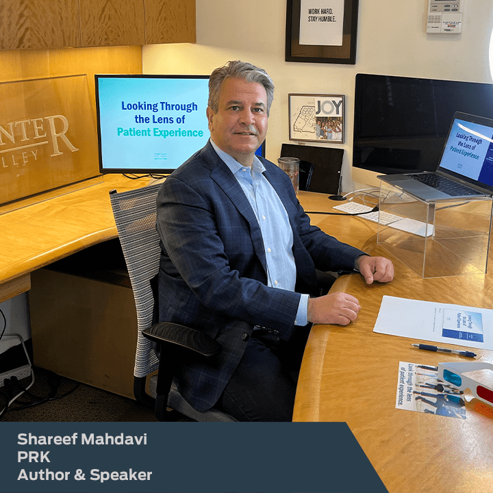 Photo of Shareef Mahdavi, Author & speaker, sitting in front of Laser Eye Center of Silicon Valley desk with 2 comuter screens. PRK Patient.