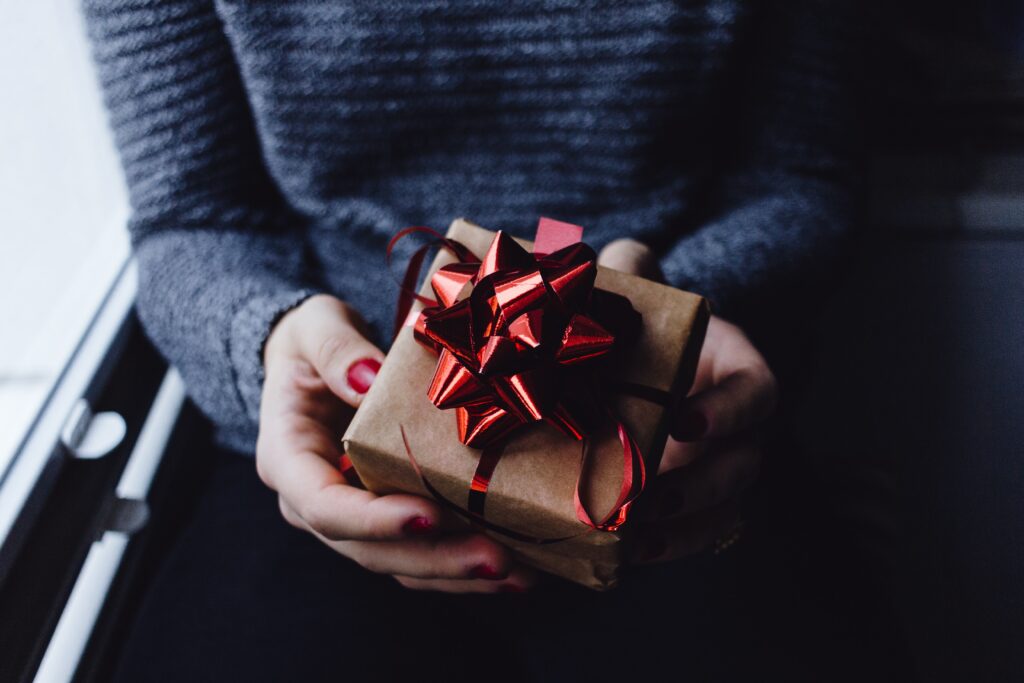 Woman holding a gift for LEC's 2023 Holiday Gift Special