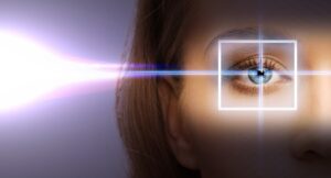 Close up of an eye with a laser pointing towards the pupil - So What is Wavefront LASIK?